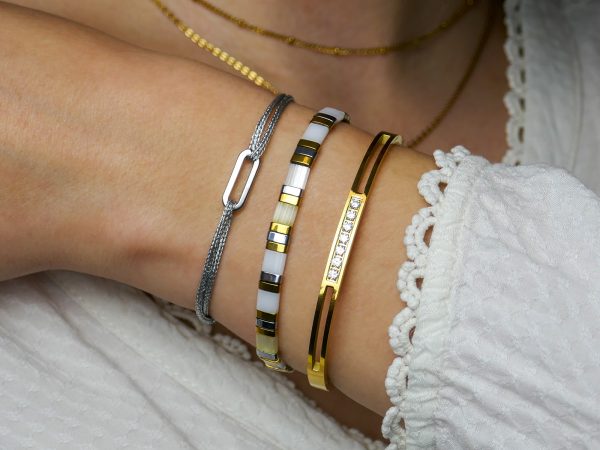 Jonc articulé rehaussé d'oxydes de zirconium blancs en acier inoxydable doré